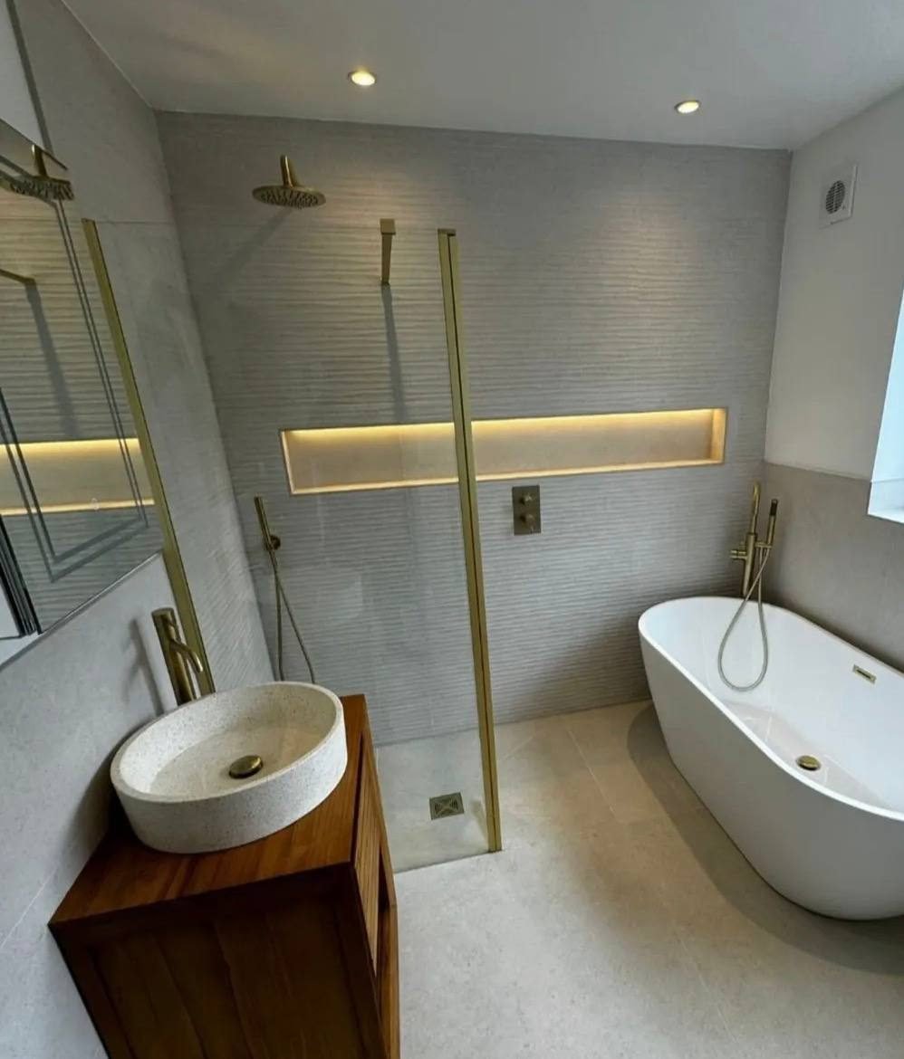 Freestanding bath and walk-in shower with brushed brass taps